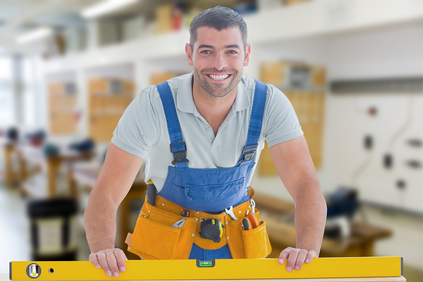 Worker using spirit level against workshop